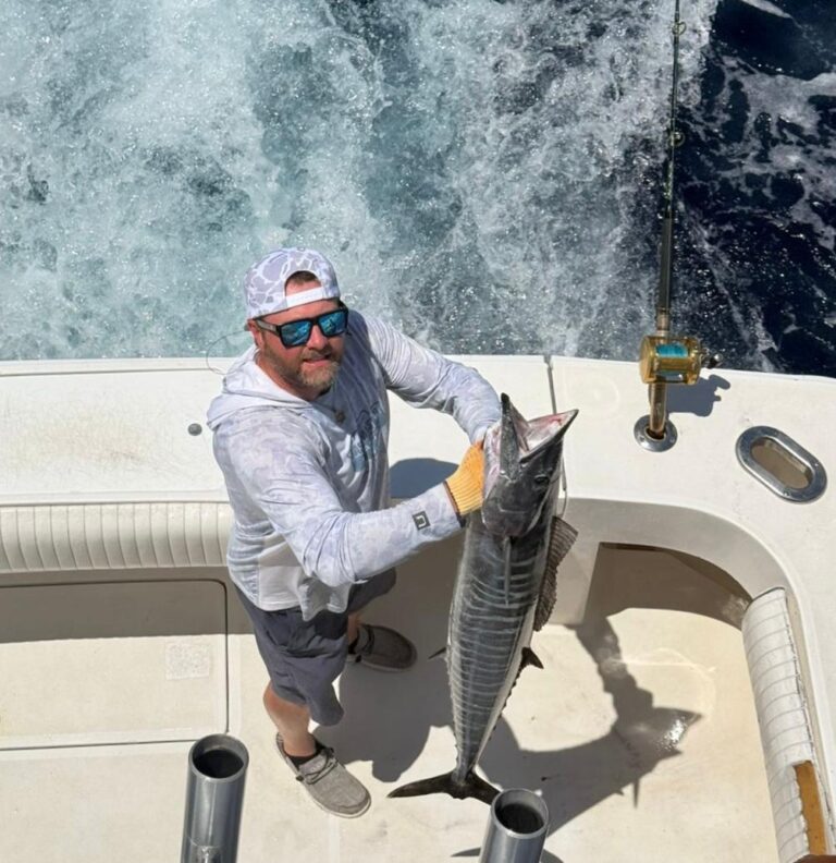 Guest holding a large wahoo caught on an 8-hour private fishing charter out of Puerto Aventuras, Riviera Maya