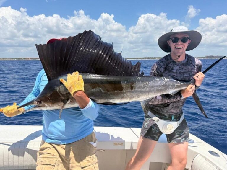 Captain and guest holding an Atlantic sailfish before release on an 8-hour private fishing charter out of Puerto Aventuras, Riviera Maya